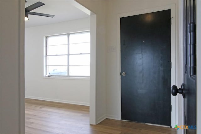 entryway with baseboards, wood finished floors, and a ceiling fan