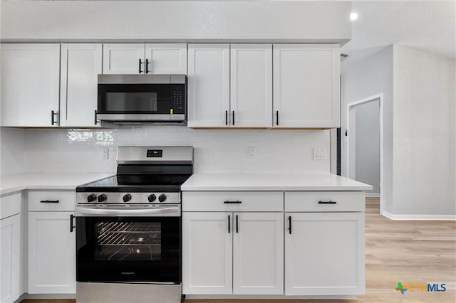 kitchen with light hardwood / wood-style floors, white cabinetry, decorative backsplash, and stainless steel appliances