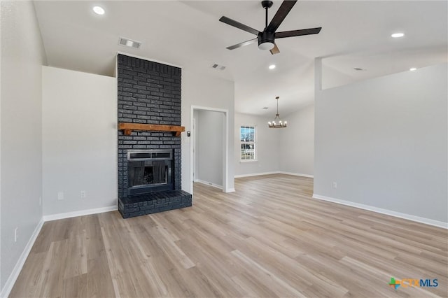 unfurnished living room with light wood-type flooring, a fireplace, and ceiling fan with notable chandelier