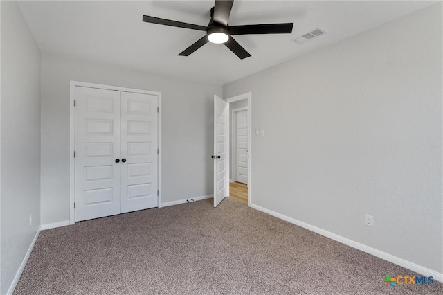 unfurnished bedroom featuring ceiling fan, carpet flooring, and a closet