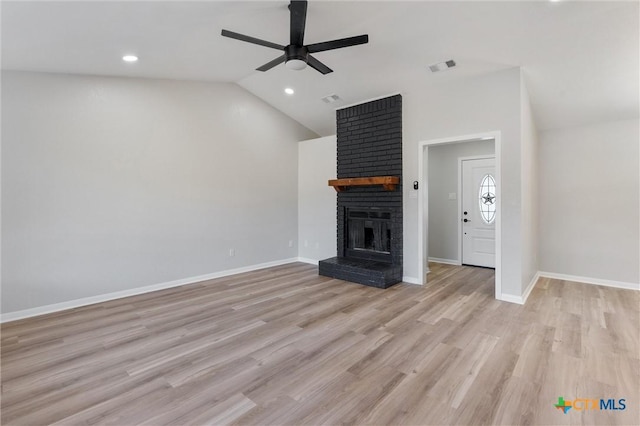 unfurnished living room with light wood-type flooring, a brick fireplace, lofted ceiling, and ceiling fan