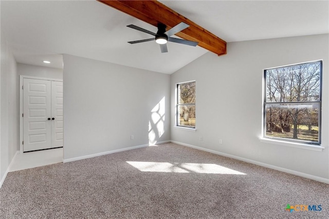 carpeted spare room featuring ceiling fan and lofted ceiling with beams