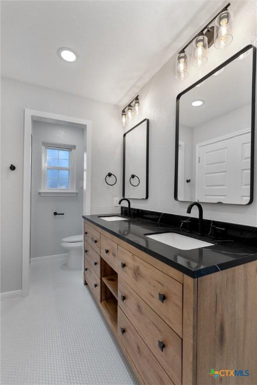 bathroom featuring toilet, tile patterned flooring, and vanity