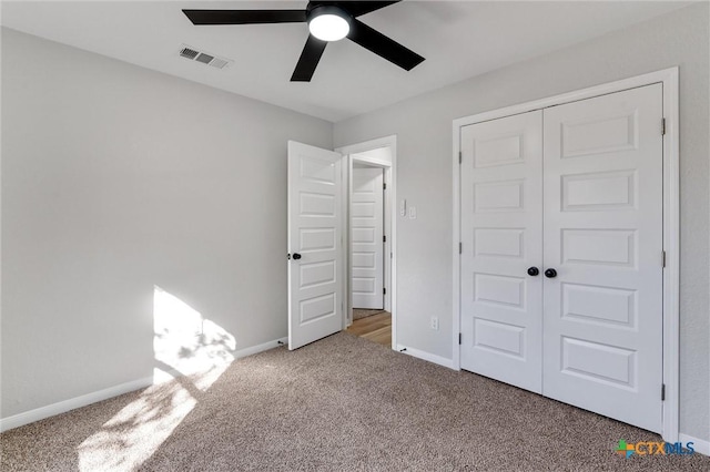 unfurnished bedroom with ceiling fan, a closet, and carpet flooring