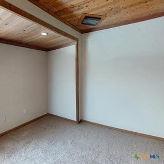 501 Live Oak St, Gatesville, TX 76528 - spare room with wood ceiling, light colored carpet, baseboards, and recessed lighting