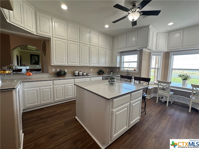 kitchen with a center island, white cabinets, ceiling fan, dark hardwood / wood-style flooring, and kitchen peninsula