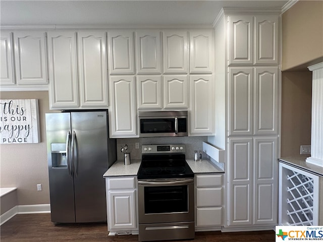 kitchen featuring dark hardwood / wood-style flooring, white cabinets, and stainless steel appliances