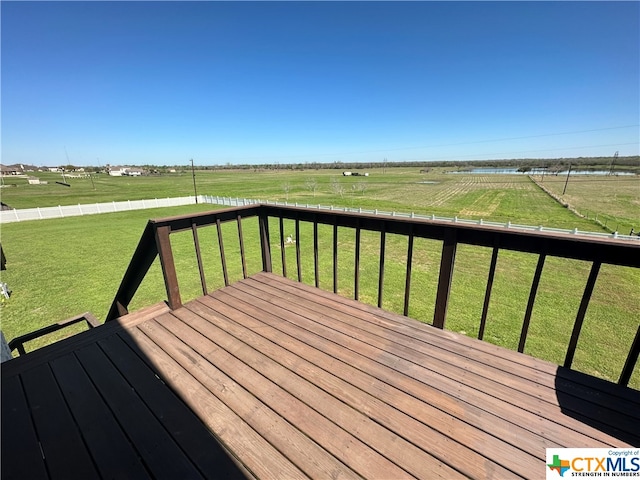 wooden terrace featuring a yard and a rural view