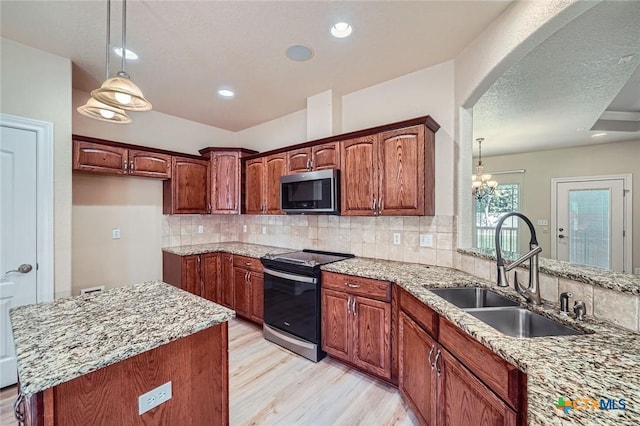 240 Hummingbird Way, Martindale, TX 78655 - kitchen with appliances with stainless steel finishes, a sink, light wood-type flooring, tasteful backsplash, and light stone counters