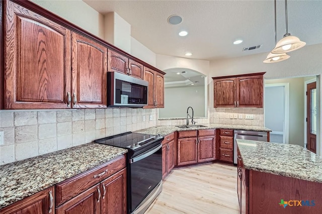 240 Hummingbird Way, Martindale, TX 78655 - kitchen featuring stainless steel appliances, a sink, light wood-type flooring, light stone counters, and decorative light fixtures