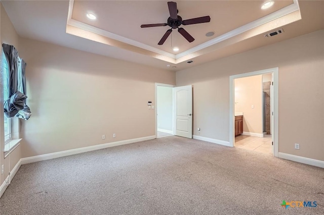 240 Hummingbird Way, Martindale, TX 78655 - unfurnished bedroom with a tray ceiling, ornamental molding, light carpet, recessed lighting, and baseboards
