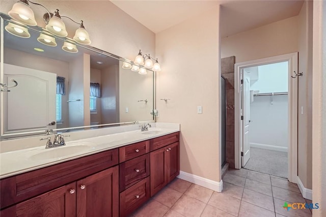 240 Hummingbird Way, Martindale, TX 78655 - bathroom featuring a shower stall, double vanity, tile patterned flooring, a spacious closet, and baseboards