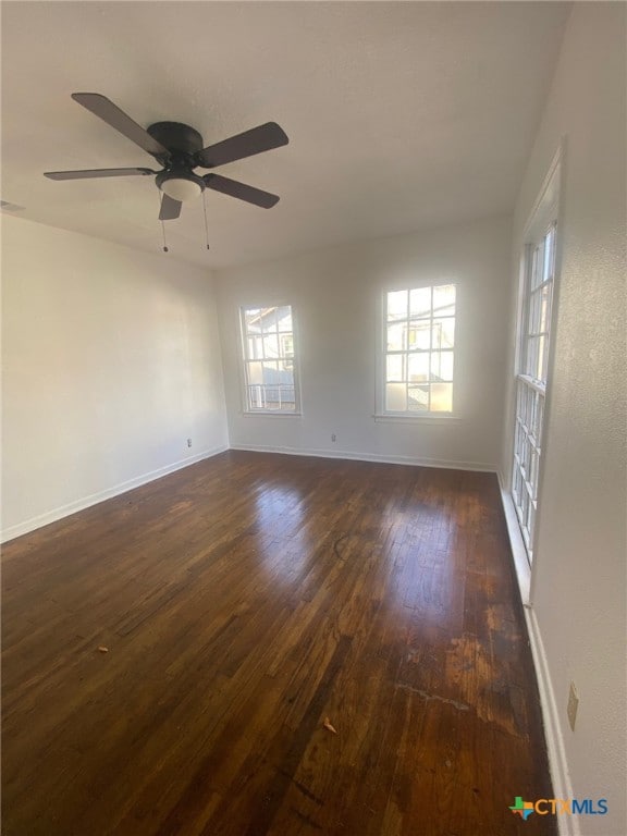 spare room with ceiling fan and dark hardwood / wood-style floors