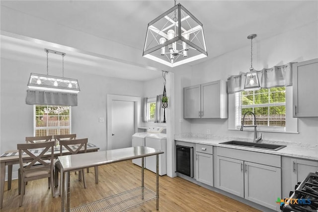 905 N Navarro St, Victoria, TX 77901 - kitchen featuring separate washer and dryer, gray cabinets, beverage cooler, and light wood-style flooring