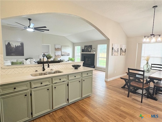 421 Arapaho Dr, Harker Heights, TX 76548 - kitchen with a sink, green cabinetry, vaulted ceiling, arched walkways, and light wood-style flooring