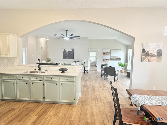 421 Arapaho Dr, Harker Heights, TX 76548 - kitchen featuring green cabinets, a peninsula, arched walkways, light wood-style flooring, and lofted ceiling