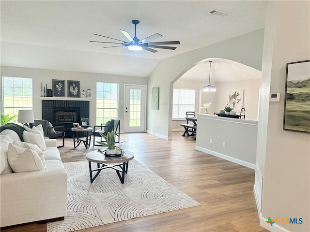 421 Arapaho Dr, Harker Heights, TX 76548 - living room with lofted ceiling, arched walkways, light wood finished floors, ceiling fan, and plenty of natural light