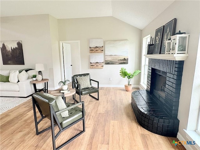 421 Arapaho Dr, Harker Heights, TX 76548 - living room with vaulted ceiling, wood finished floors, a brick fireplace, and baseboards