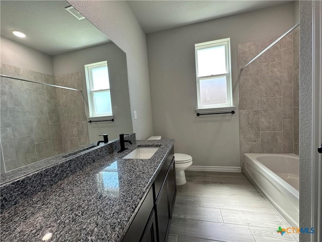 full bathroom with vanity, toilet, baseboards, and shower / tub combination