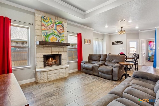 living area with a wealth of natural light, ornamental molding, a textured ceiling, and visible vents