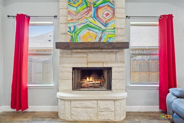 details featuring a fireplace, baseboards, and wood finished floors