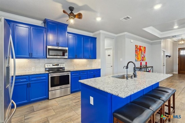 kitchen with stainless steel appliances, a breakfast bar area, a sink, and visible vents