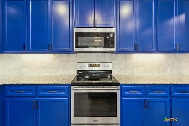 kitchen featuring light stone countertops, blue cabinetry, tasteful backsplash, and appliances with stainless steel finishes