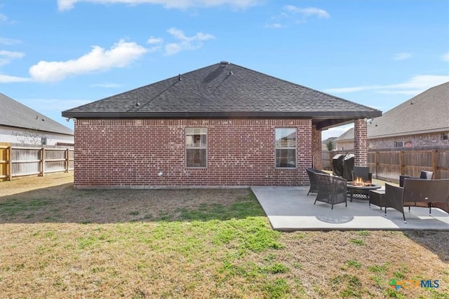 rear view of property featuring a fire pit, a patio, a fenced backyard, a yard, and brick siding