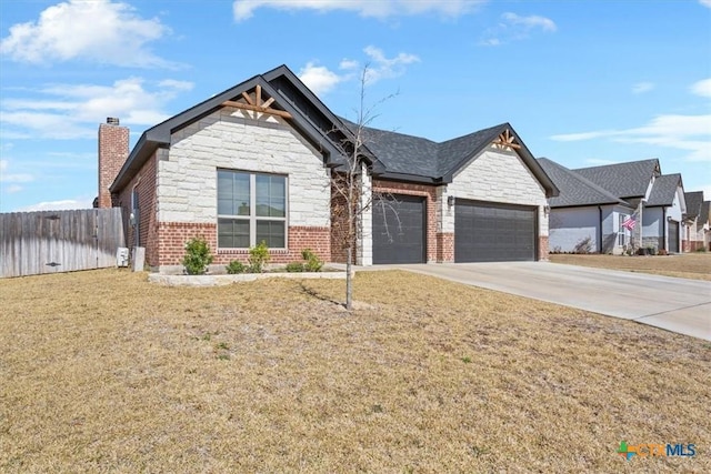 craftsman-style home featuring an attached garage, stone siding, driveway, and fence