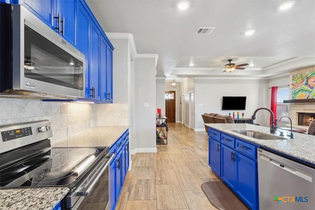 kitchen with stainless steel appliances, visible vents, a sink, and blue cabinetry