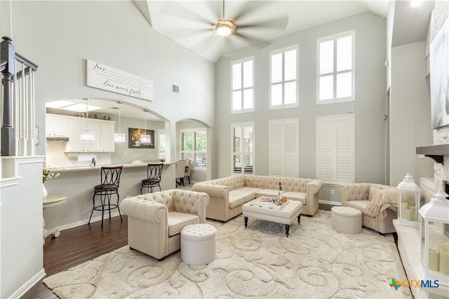 living room featuring high vaulted ceiling, hardwood / wood-style flooring, and ceiling fan