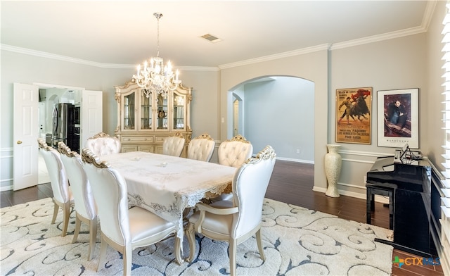 dining space with dark hardwood / wood-style floors, a chandelier, and crown molding