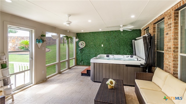 sunroom with ceiling fan and a jacuzzi