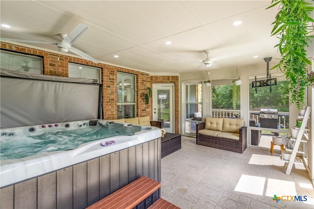 interior space with a hot tub, an outdoor hangout area, a grill, and ceiling fan