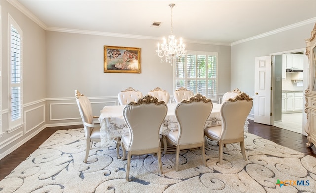 dining space with dark hardwood / wood-style floors, an inviting chandelier, and crown molding