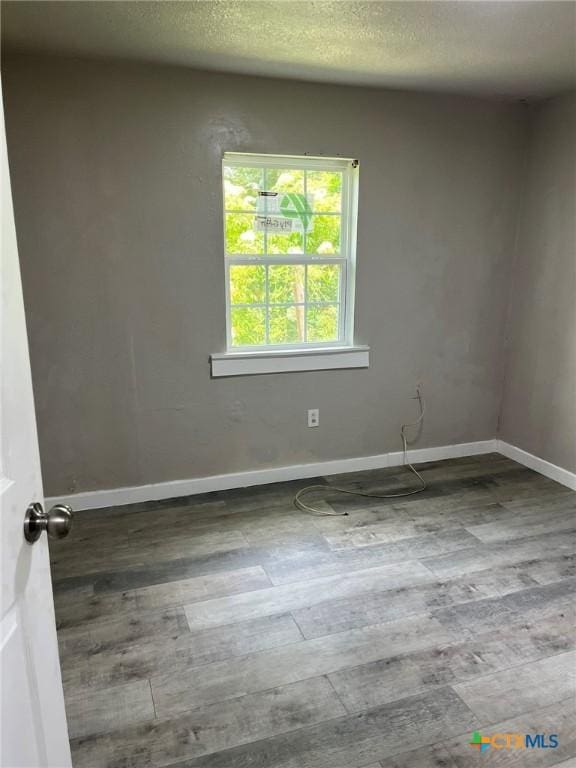 255 Pollard St, Beaumont, TX 77703 - empty room with wood finished floors, baseboards, and a textured ceiling