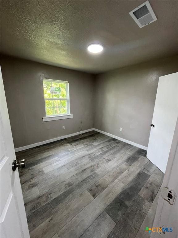 255 Pollard St, Beaumont, TX 77703 - empty room with wood finished floors, baseboards, and a textured ceiling