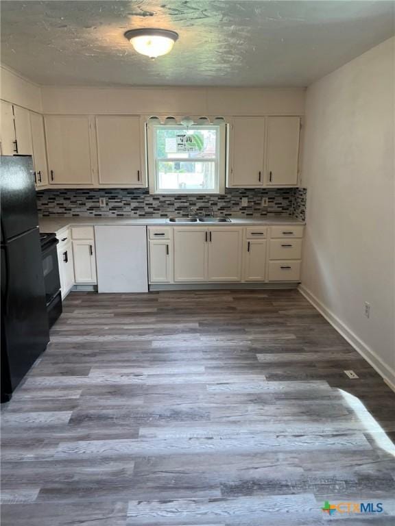 255 Pollard St, Beaumont, TX 77703 - kitchen featuring black appliances, a sink, white cabinets, decorative backsplash, and wood finished floors