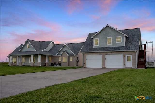 105 N Redfish Retreat Dr, Port Lavaca, TX 77979 - view of front facade with driveway, stairway, a garage, a lawn, and a shingled roof