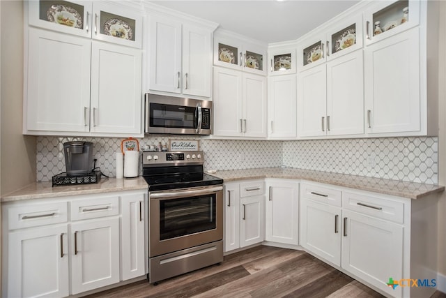 kitchen with dark wood-type flooring, white cabinetry, appliances with stainless steel finishes, and backsplash