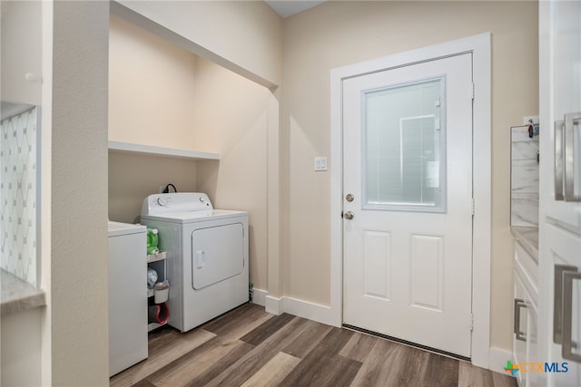 clothes washing area featuring washer and clothes dryer and hardwood / wood-style floors