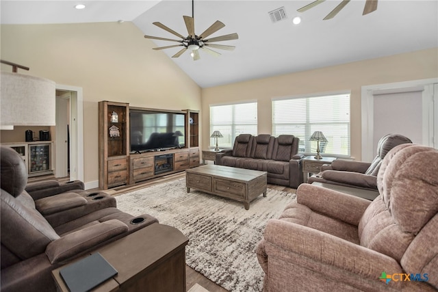 living room featuring high vaulted ceiling, light hardwood / wood-style floors, and ceiling fan