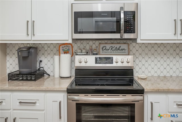 kitchen featuring light stone countertops, white cabinets, decorative backsplash, and stainless steel appliances