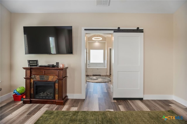 living room featuring a barn door and hardwood / wood-style flooring