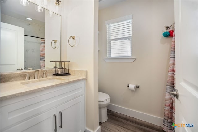 bathroom featuring wood-type flooring, vanity, and toilet