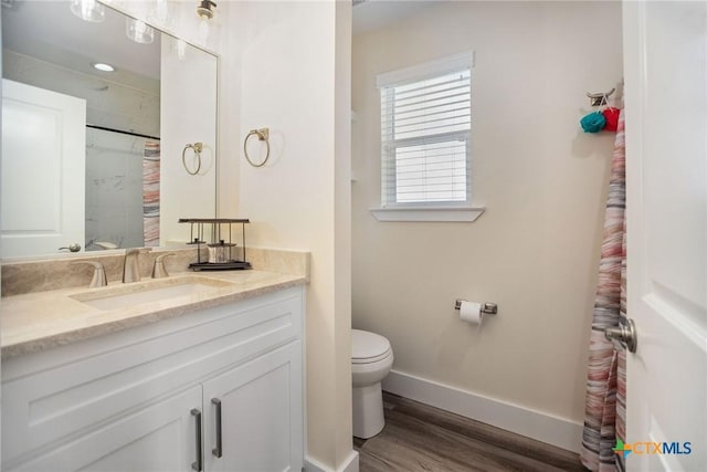 105 N Redfish Retreat Dr, Port Lavaca, TX 77979 - full bathroom with baseboards, vanity, wood finished floors, toilet, and a shower with curtain