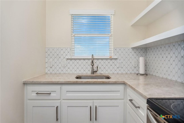 105 N Redfish Retreat Dr, Port Lavaca, TX 77979 - kitchen with a sink, open shelves, white cabinets, backsplash, and light stone counters