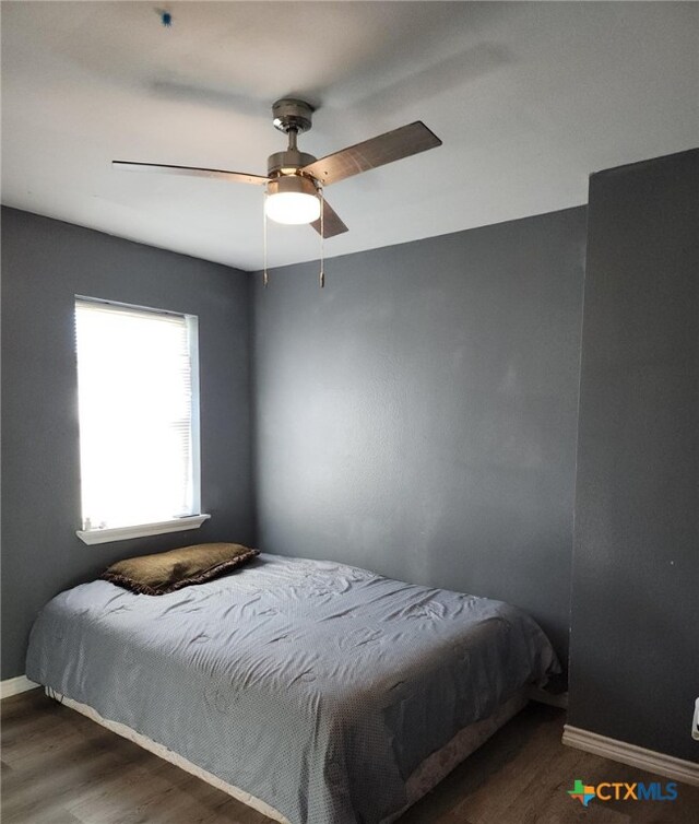 bedroom with ceiling fan and dark hardwood / wood-style flooring