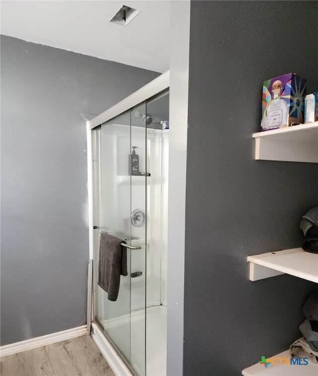 bathroom with wood-type flooring and walk in shower