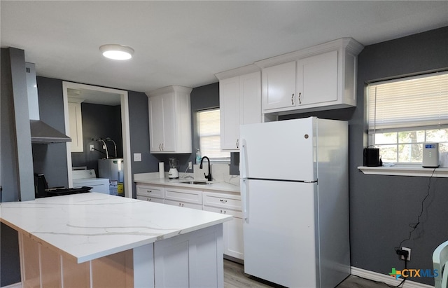 kitchen with white cabinets, sink, white fridge, and plenty of natural light